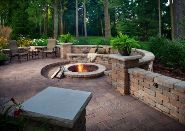 Garcias Landscaping Beaverton, Beautiful backyard with round shaped brick pavers in Portland and Retaining walls and stone retaining wall with fire pit in the middle