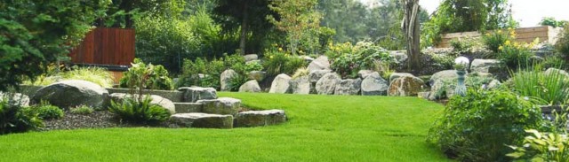 Big backyard perfectly maintained, lawn mowed and decorated with big rocks and natural stone, Landscape Maintenance Portland