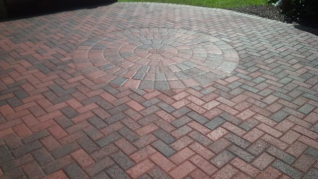 Beautiful brick paver patio rounded in the center and straight on the edges, backyard usable space, brown grays brick paver color