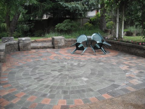 rounded brawn grey brick paver patio floor with area for outdoor furniture.